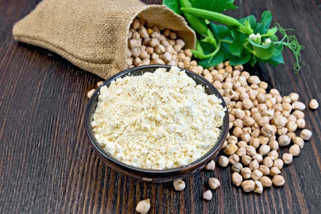 Flour chickpeas in bowl with peas on board