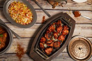 Variety of Indian curry food with tandoori chicken and basmati rice.